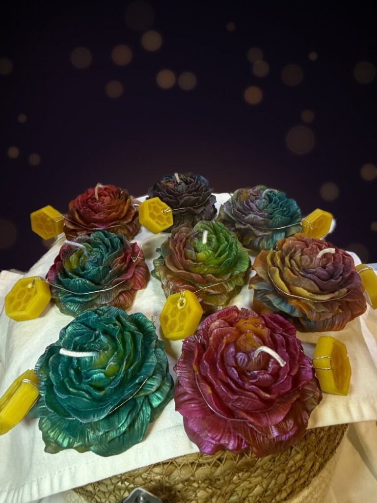 Eight Conway Candle Sanctuary beeswax rose candles with multicolor mica in teal, magenta, gold and violet, with honeycomb beeswax tags, on a cloth-covered basket